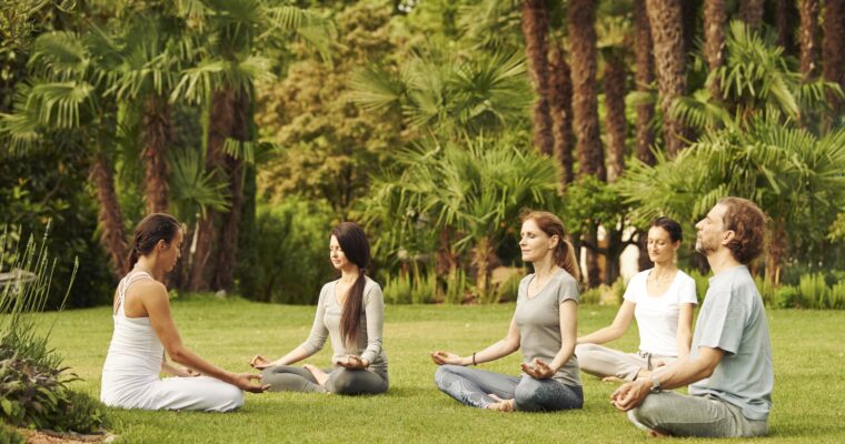 Fünf Personen machen Yoga im Garten vom Giardino Ascona