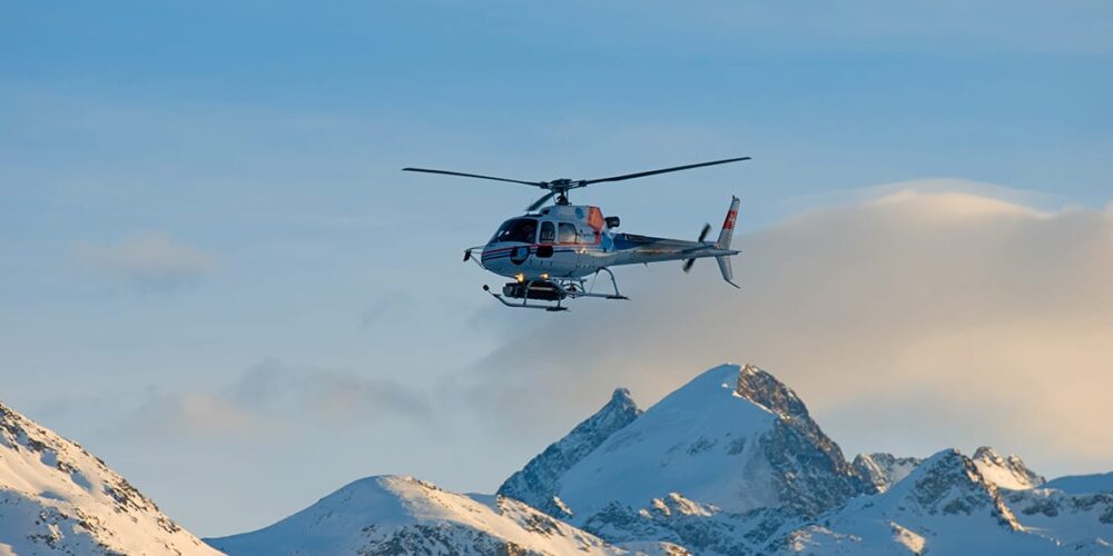 A helicopter flies through the winter landscape