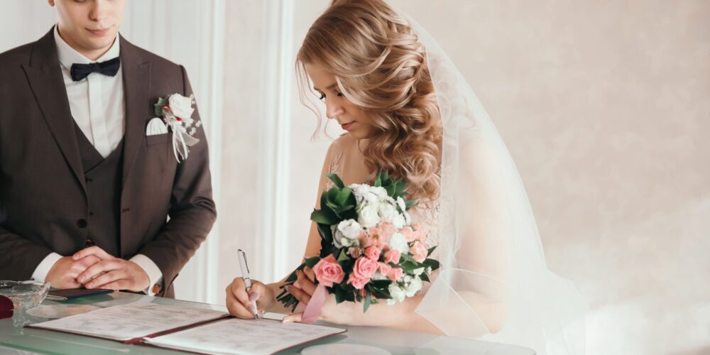 Braut unterschreibt die Papiere beim Standesamt